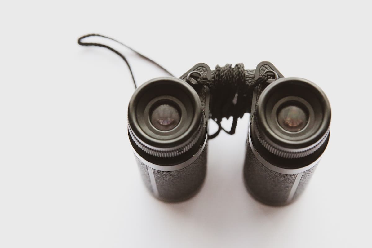 Black binoculars on a white surface. 