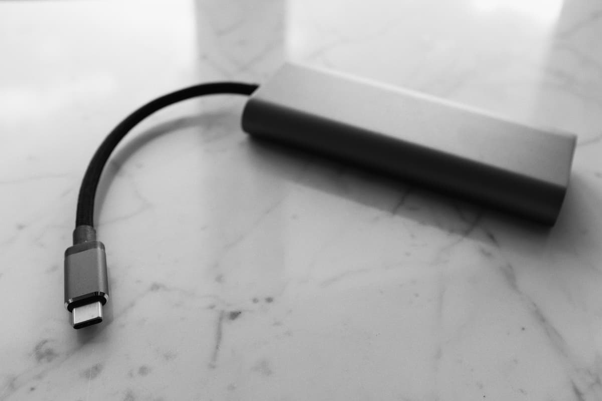 Black portable charger on marble floor tiles.