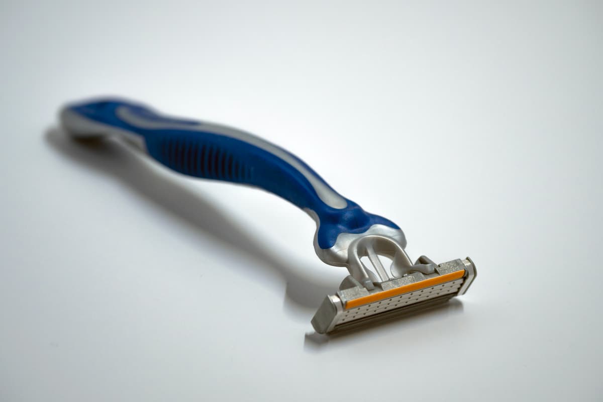 A blue and silver razor on a white surface. 