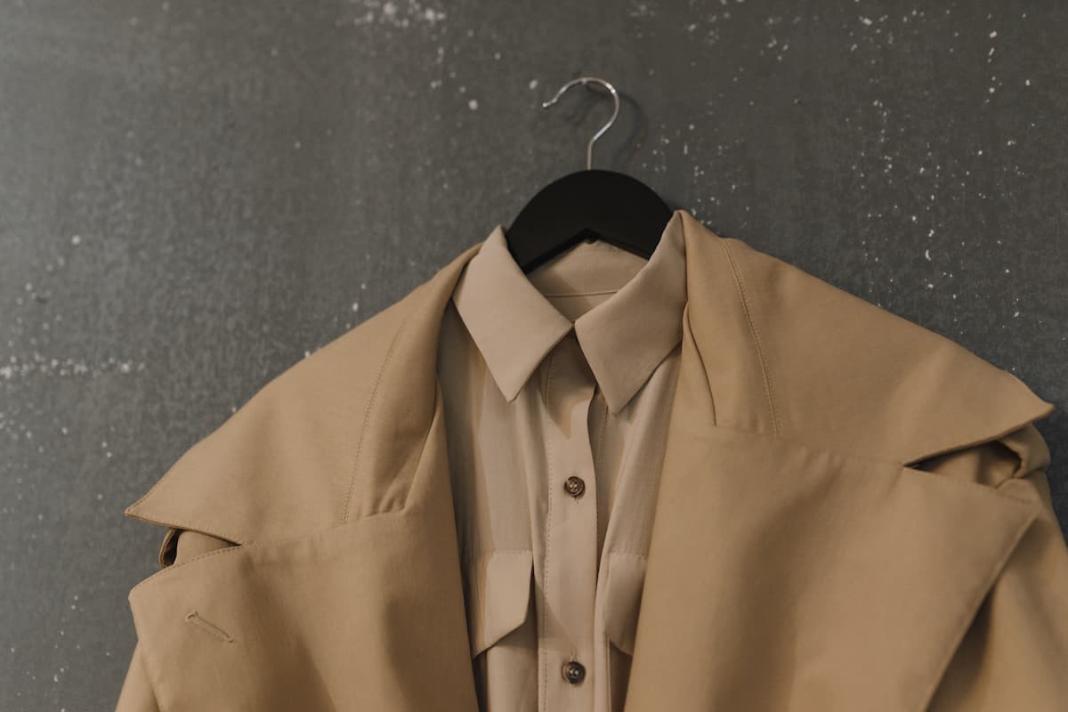 Brown coat and brown shirt on a hanger.