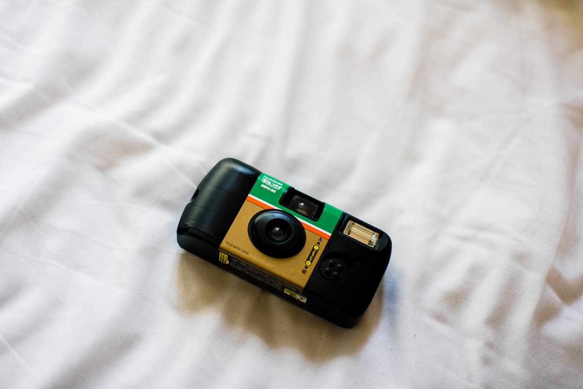 Fuji disposable camera on a white bed. 