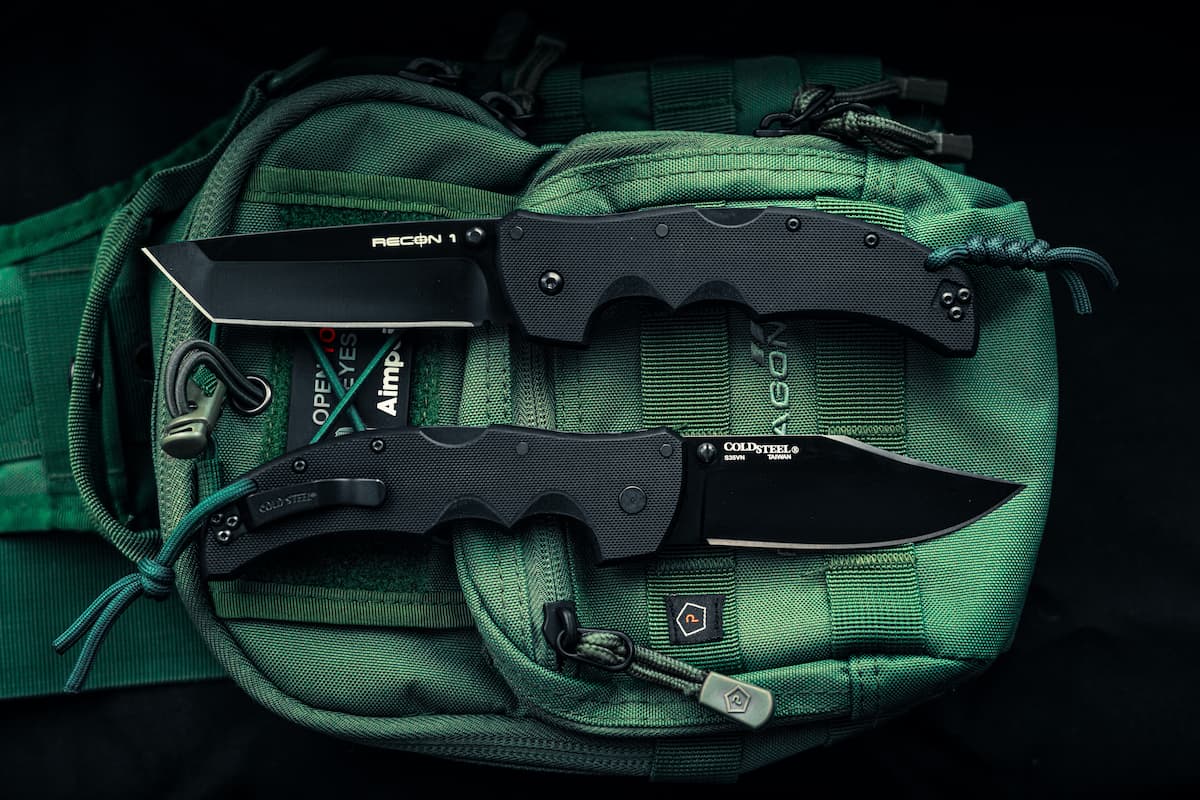 Two knives on the green bag with a black background.