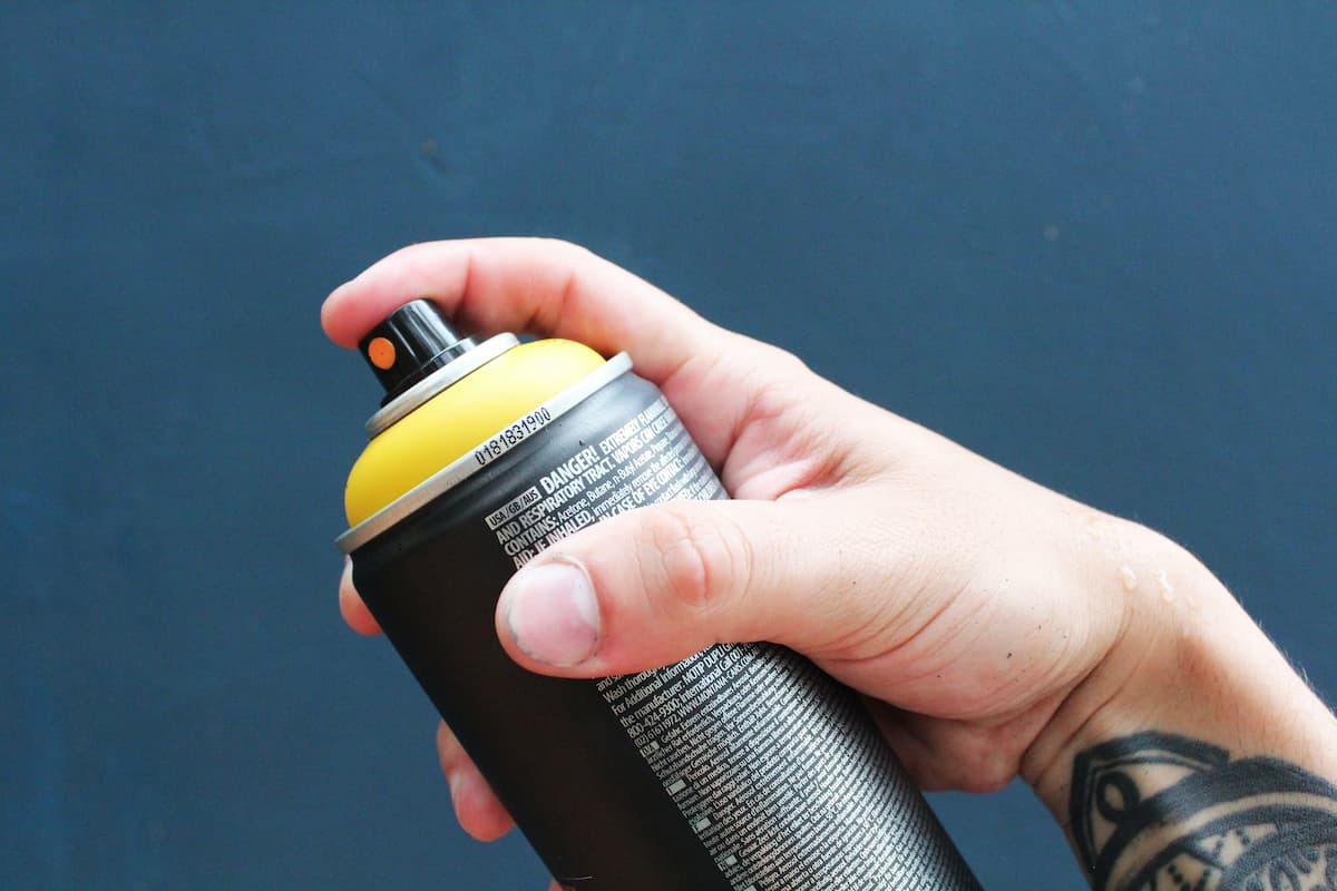 A person holding an aerosol product.