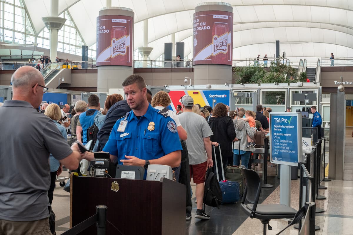 A TSA agent passes a man through the security checkpoint at the airport. 