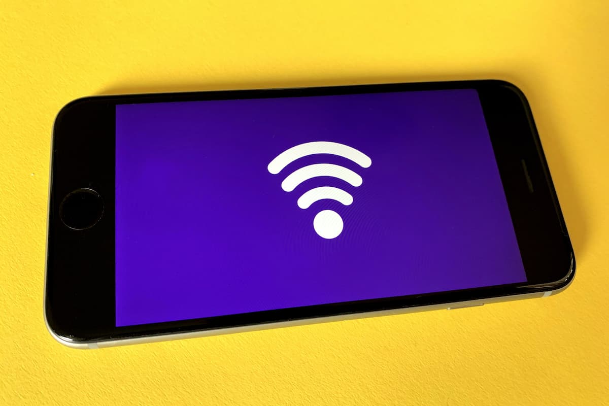 A smartphone with a wifi icon on a yellow background. 