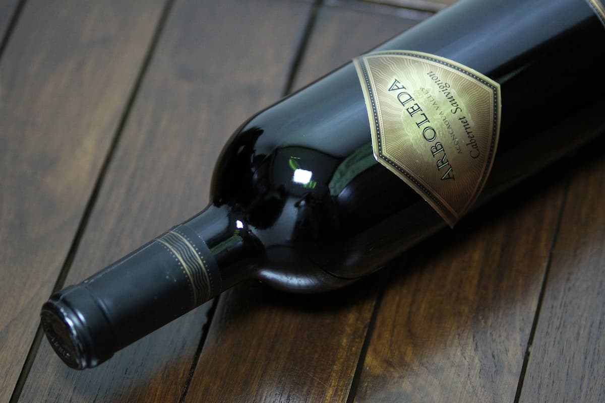 A bottle of wine on a wooden surface. 