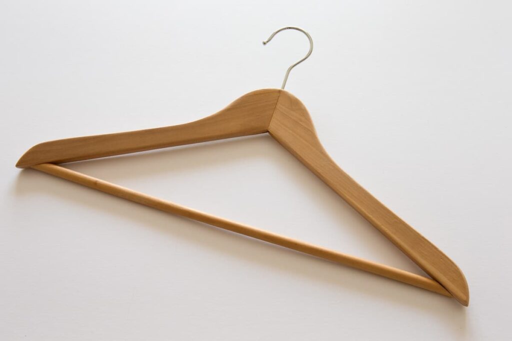 A wooden coat hanger on a white background.