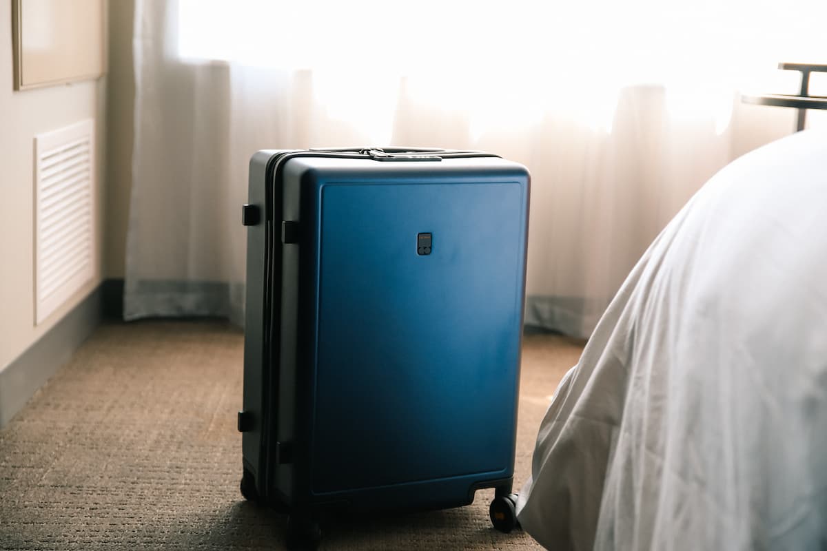 Blue luggage in a carpeted room. 