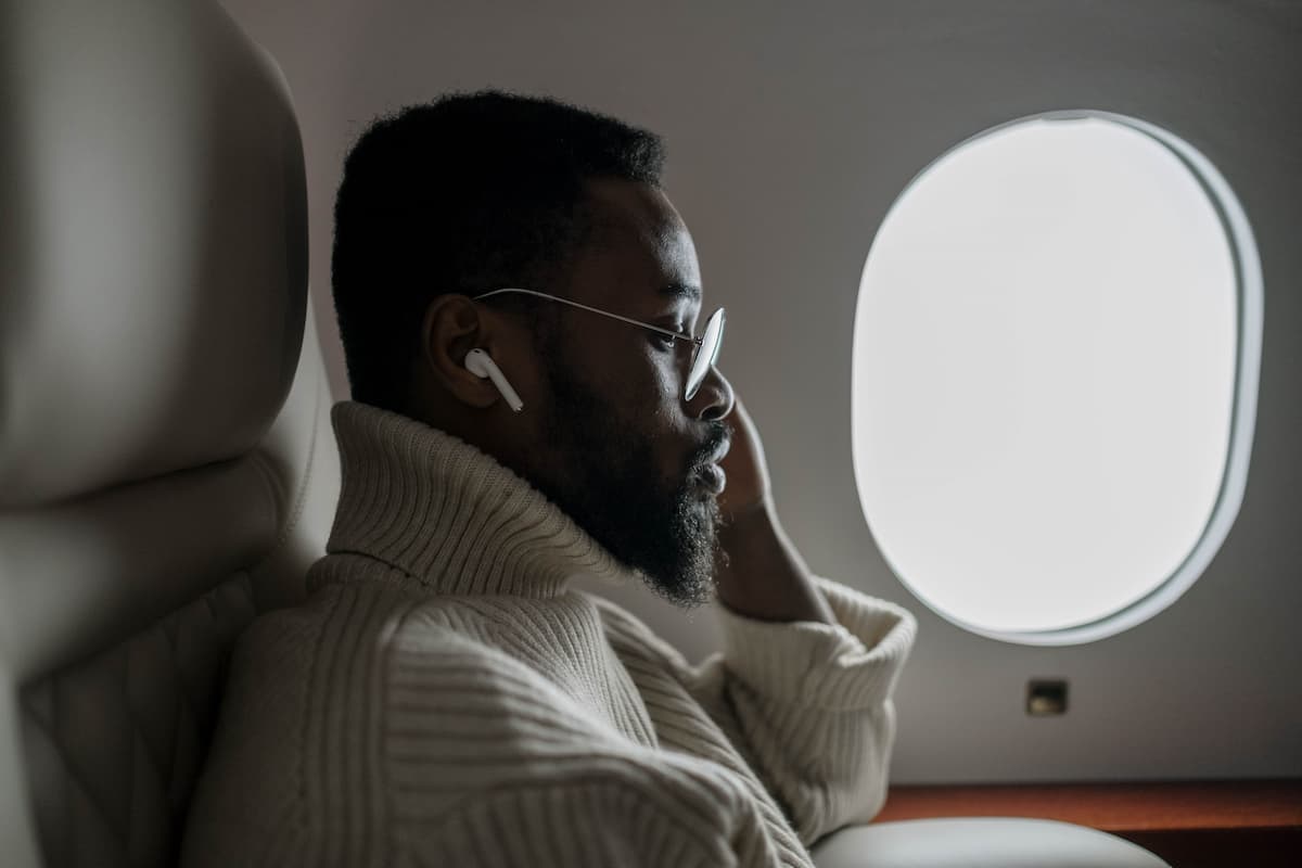 A man using AirPods on the plane. 