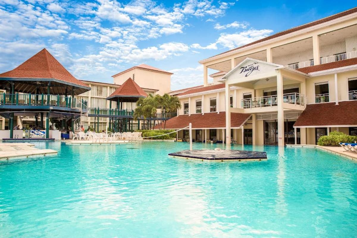 The pool in Breezes Resort & Spa Bahamas surrounded by a gazebo and the main building.