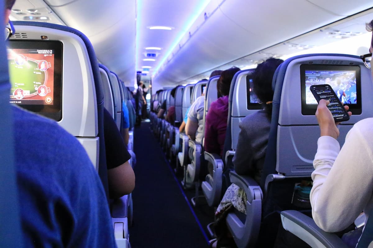 Airplane aisle with flight passengers sitting. 