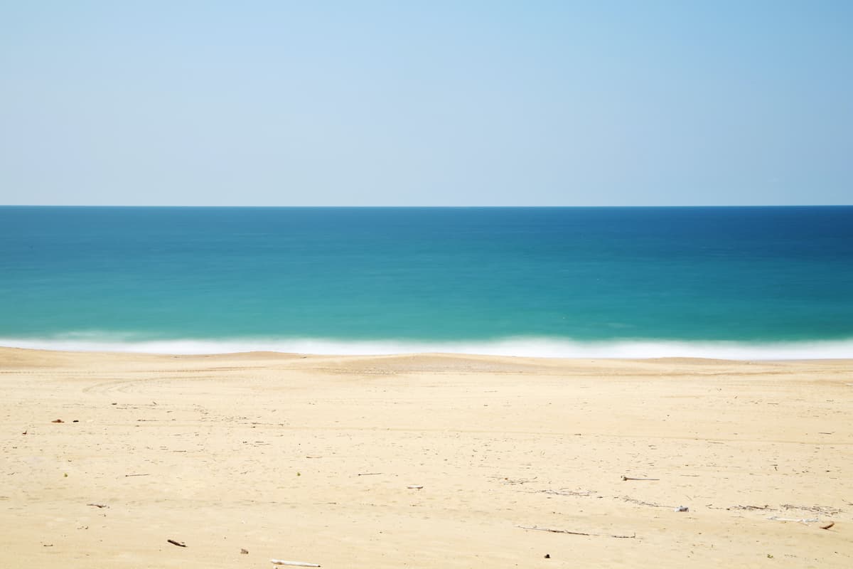 A blue sea and a white sand. 
