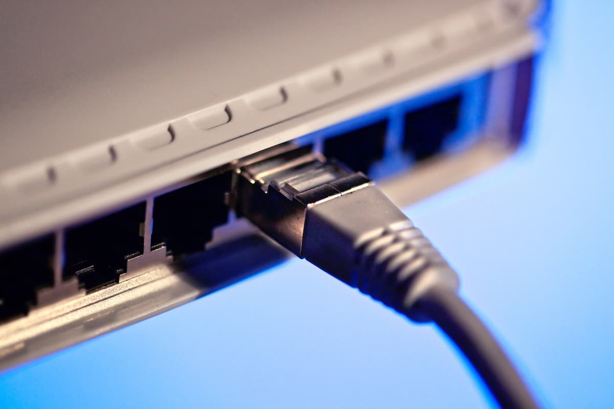 Close-up photo of a black ethernet cable plugged into an ethernet port. 