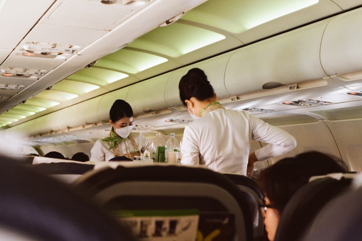 Two flight attendants serving food to passengers. 