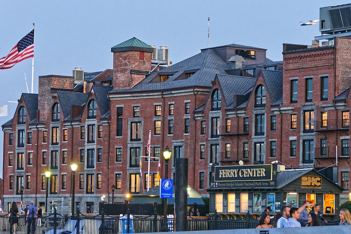 A hotel in Boston made with red bricks and a USA flag on the roof. 