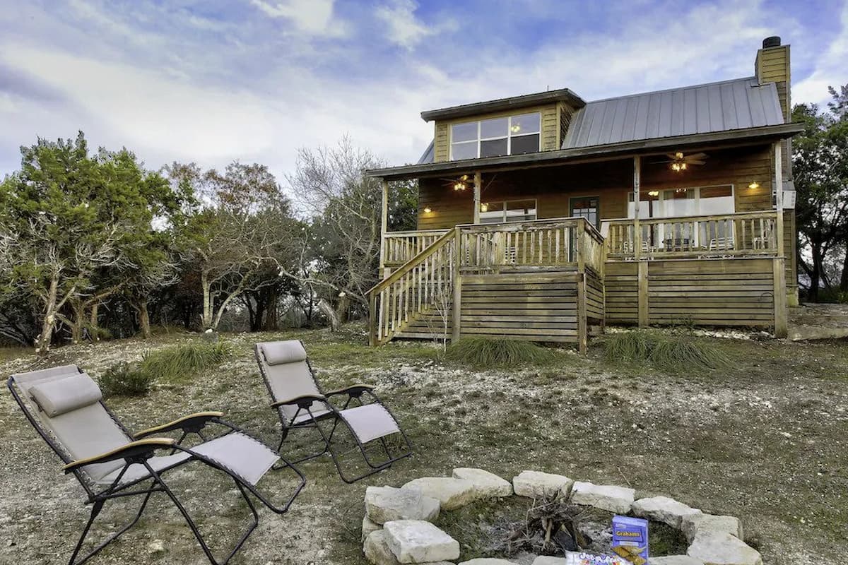 The exterior of September Ridge Cabin 1 with two folding chairs near the fire pit. 